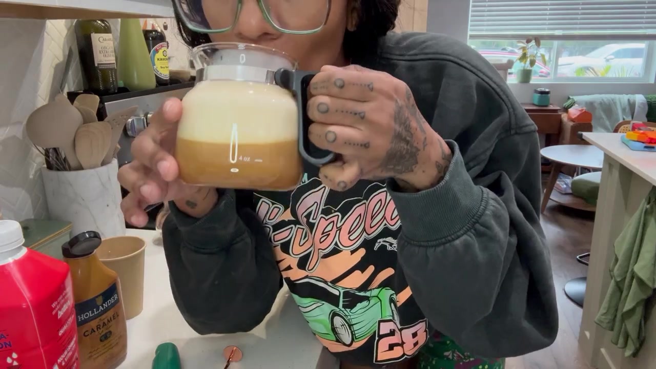 Michelle holding Sunday’s coffee, topped with a generous layer of pale foam.